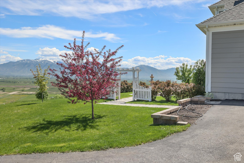 View of green lawn featuring a mountain view