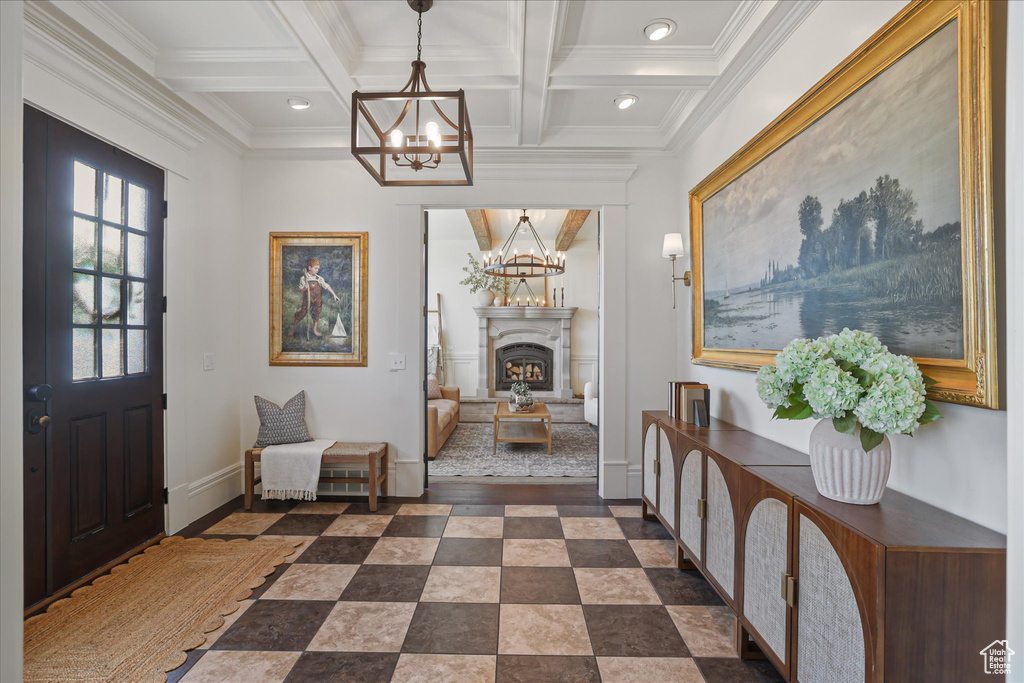 Entryway with a chandelier, ornamental molding, coffered ceiling, baseboards, and beam ceiling