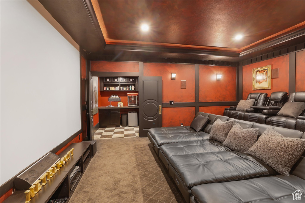 Carpeted cinema room with a raised ceiling and recessed lighting