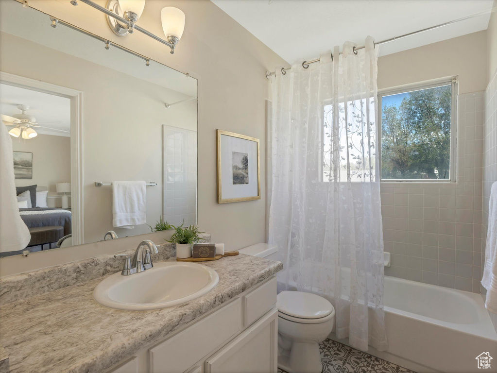 Full bath featuring shower / bath combination with curtain, vanity, toilet, and ceiling fan