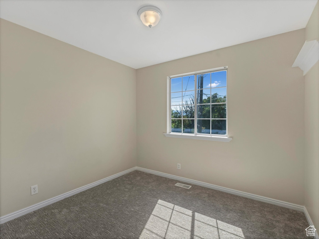Spare room featuring carpet floors and baseboards