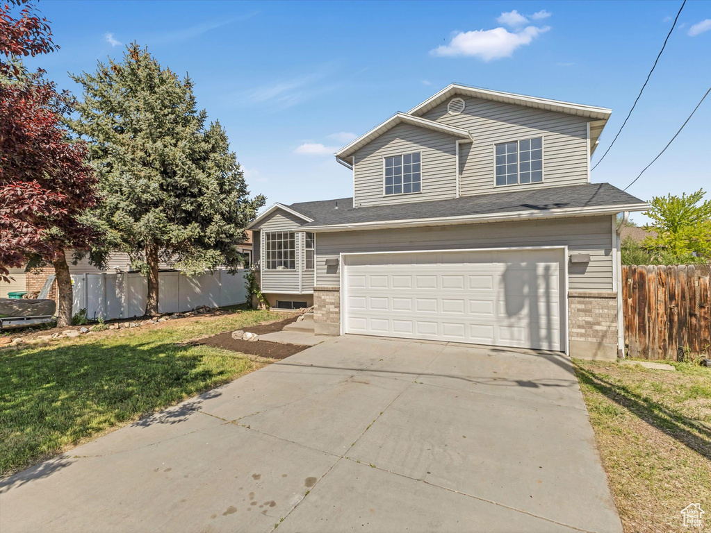 View of front of house with an attached garage, concrete driveway, and brick siding