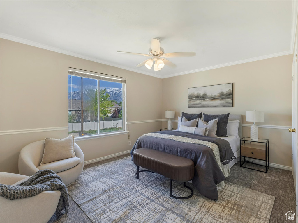 Bedroom with baseboards, crown molding, ceiling fan, and carpet