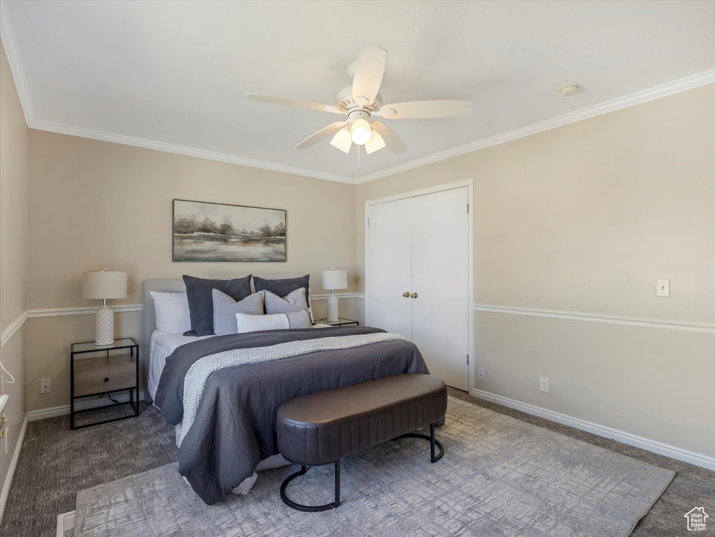 Carpeted bedroom with crown molding, ceiling fan, and baseboards