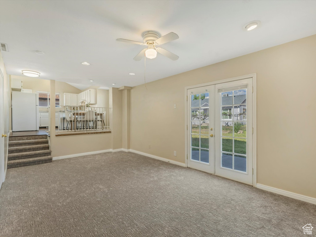 Unfurnished living room with french doors, carpet floors, ceiling fan, baseboards, and recessed lighting