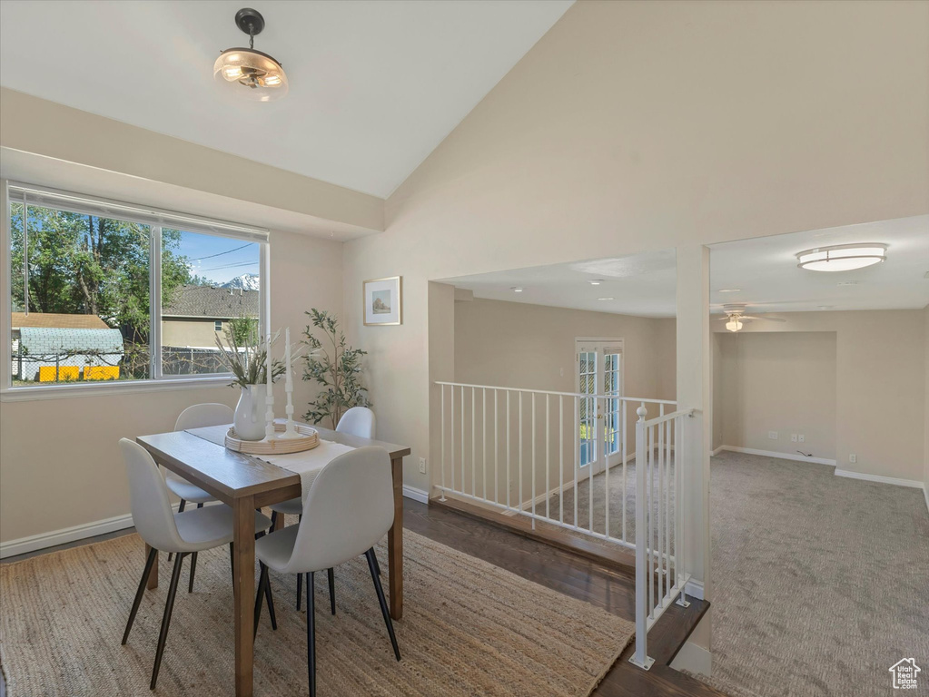 Dining space featuring plenty of natural light, baseboards, ceiling fan, vaulted ceiling, and wood finished floors