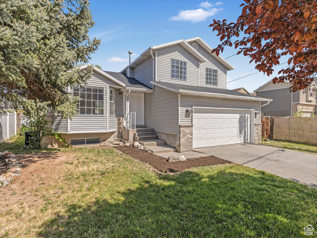 View of front of home with concrete driveway and an attached garage