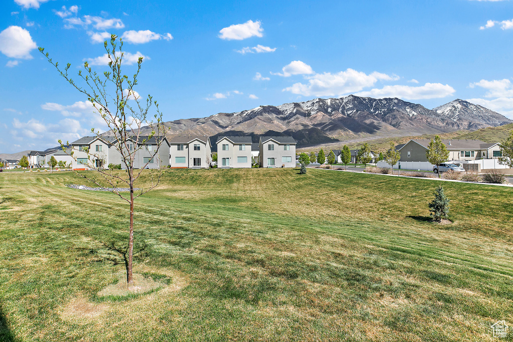 View of front facade featuring a residential view, a mountain view, and a front yard
