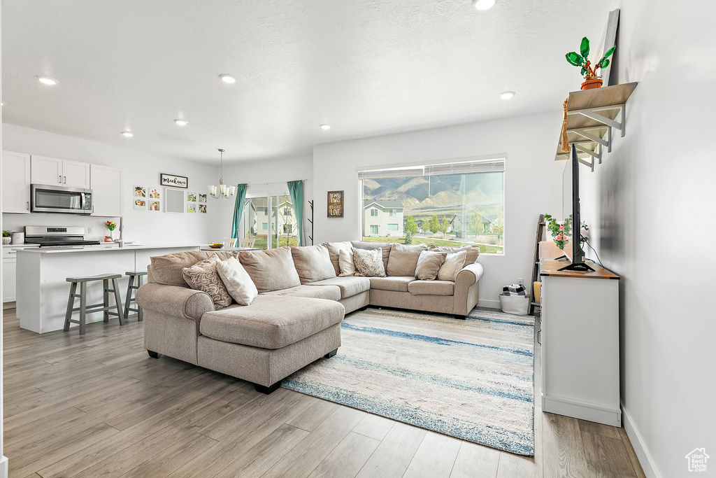Living area with light wood-style flooring and recessed lighting
