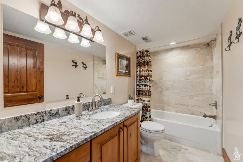 Full bath with toilet, vanity, and shower / tub combo with curtain