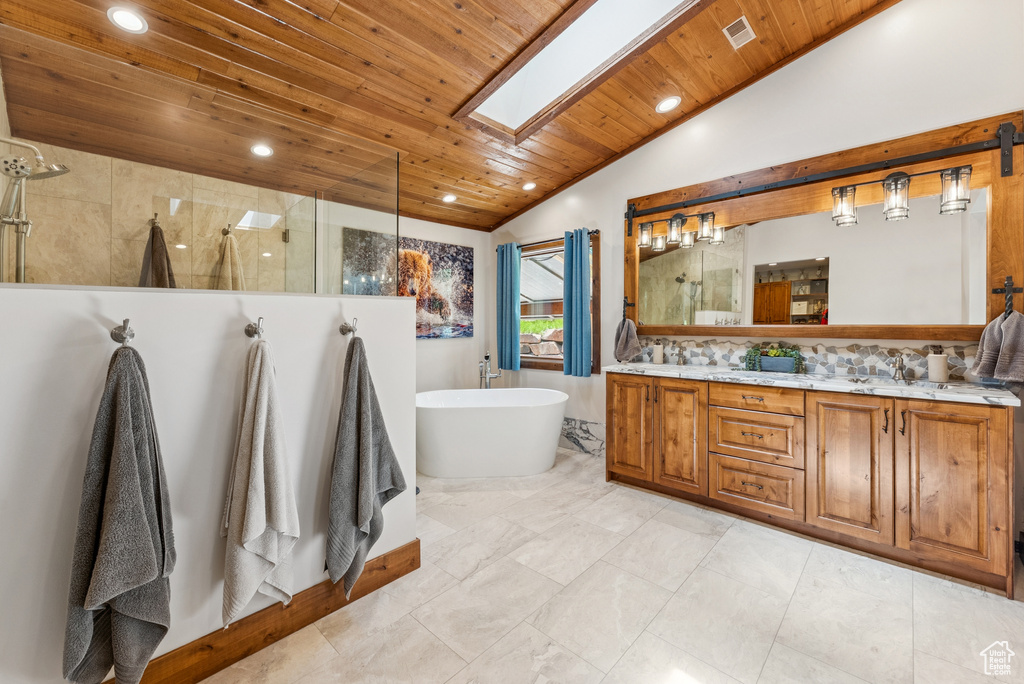 Full bath with lofted ceiling, wooden ceiling, a tile shower, double vanity, and a freestanding bath
