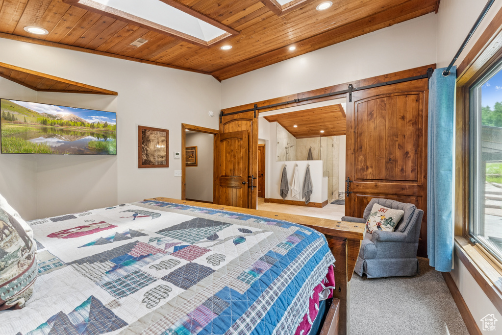 Bedroom featuring wood ceiling, a barn door, a skylight, recessed lighting, and carpet flooring