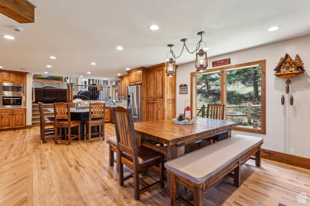 Dining area with recessed lighting, light wood-style floors, and baseboards
