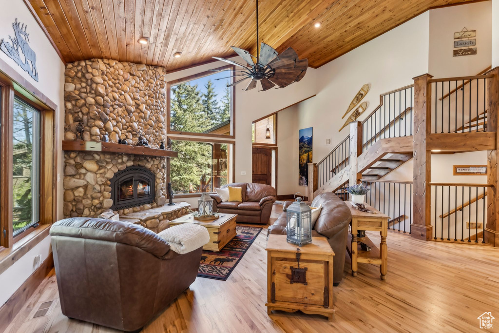 Living area with wood ceiling, healthy amount of natural light, wood finished floors, a ceiling fan, and a fireplace