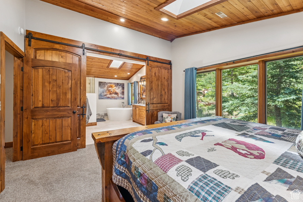 Carpeted bedroom with a barn door, wooden ceiling, a skylight, lofted ceiling, and recessed lighting