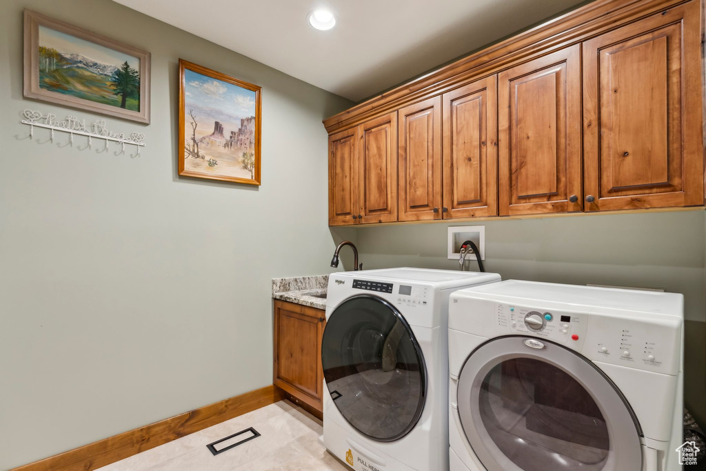 Laundry area with cabinet space, independent washer and dryer, baseboards, light tile patterned floors, and recessed lighting