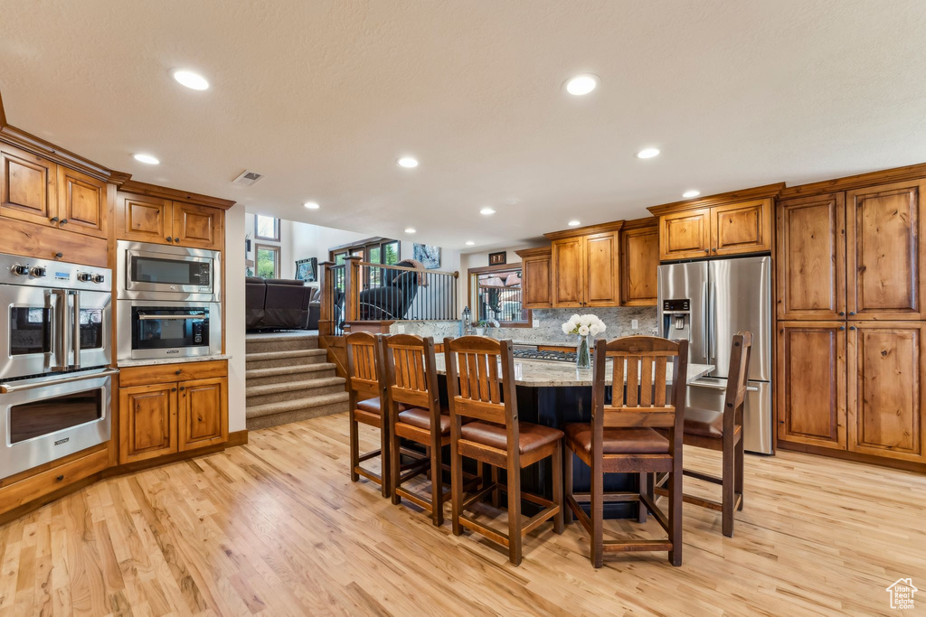 Dining area featuring light wood-style floors, recessed lighting, and stairs