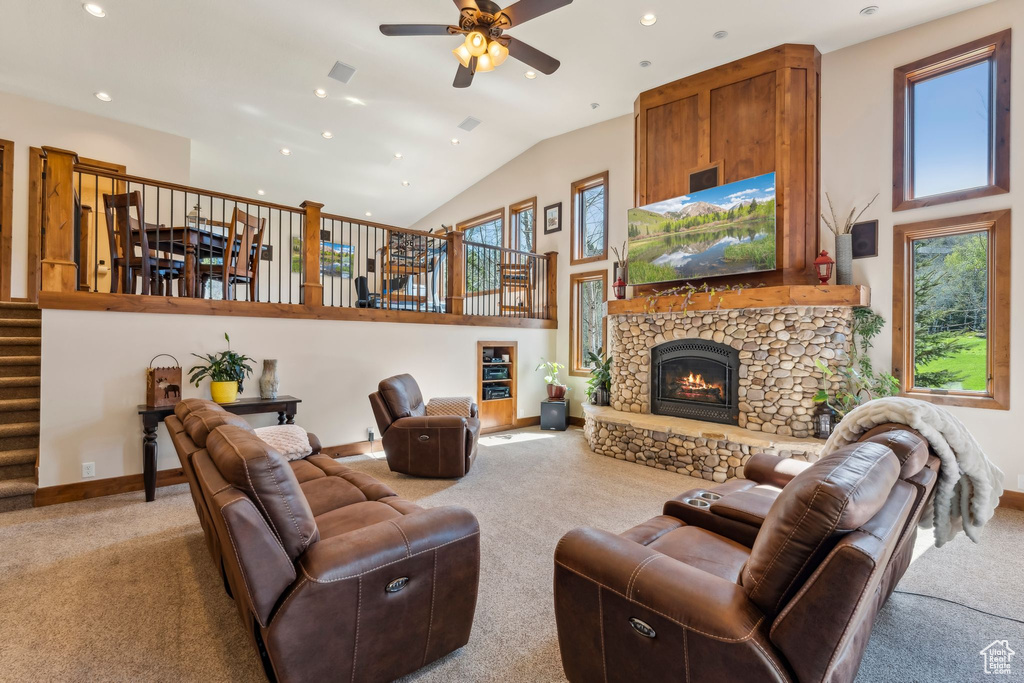 Carpeted living area featuring healthy amount of natural light, stairs, ceiling fan, high vaulted ceiling, and baseboards