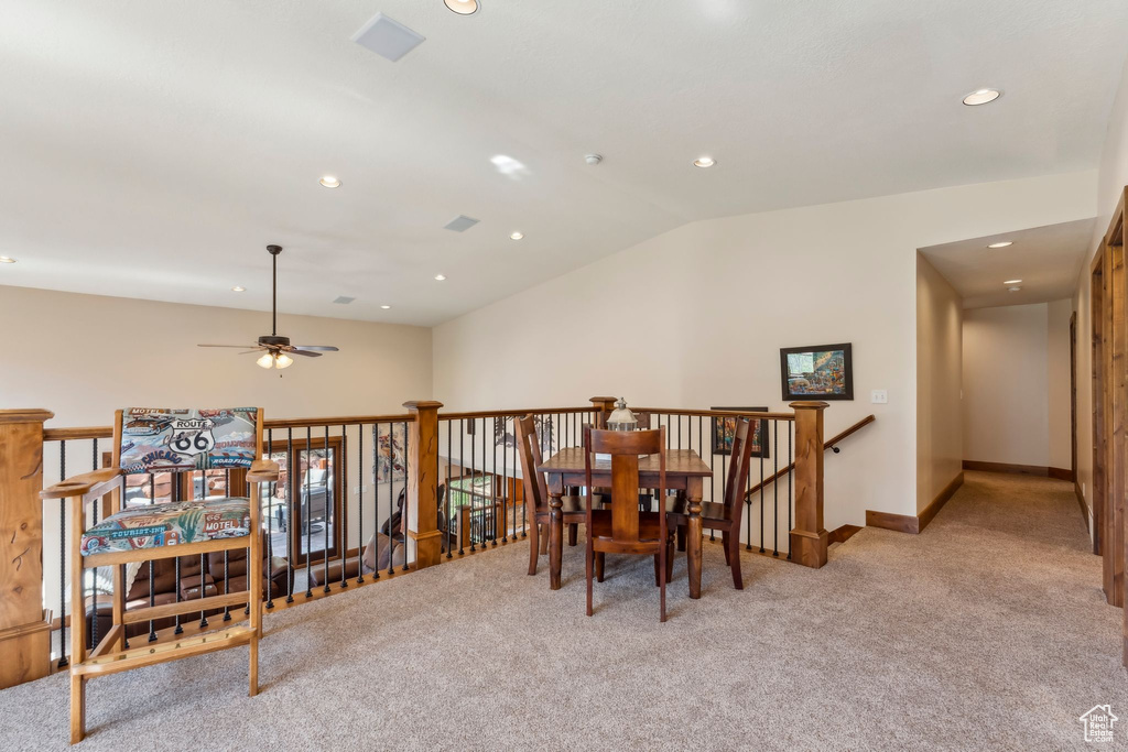 Dining space with light carpet, vaulted ceiling, baseboards, a ceiling fan, and recessed lighting