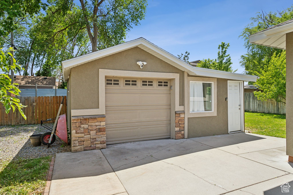 Garage featuring fence and concrete driveway