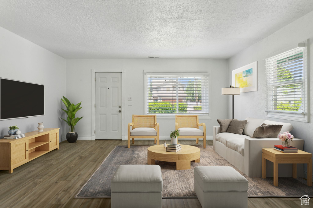Living room with a textured ceiling, wood finished floors, and baseboards