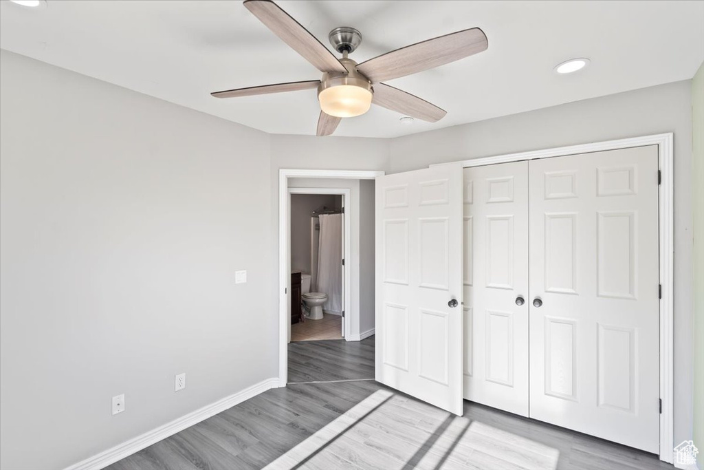 Unfurnished bedroom with wood finished floors, a closet, baseboards, recessed lighting, and a ceiling fan
