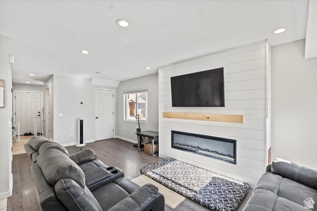 Living area with recessed lighting, a fireplace, wood finished floors, and baseboards
