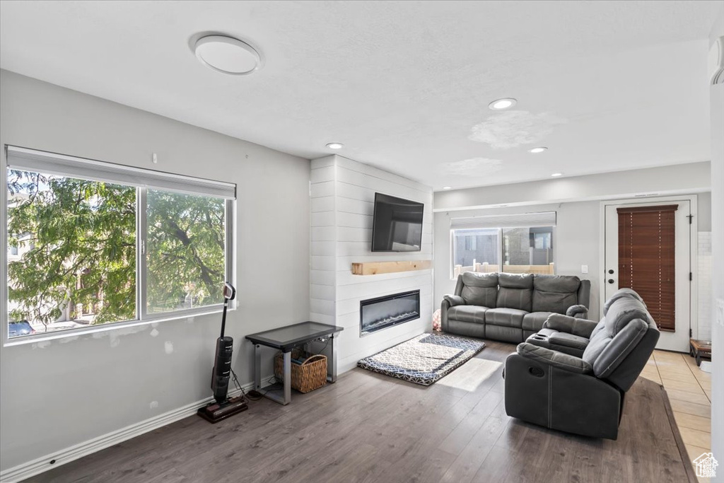 Living room featuring a fireplace, wood finished floors, recessed lighting, and baseboards