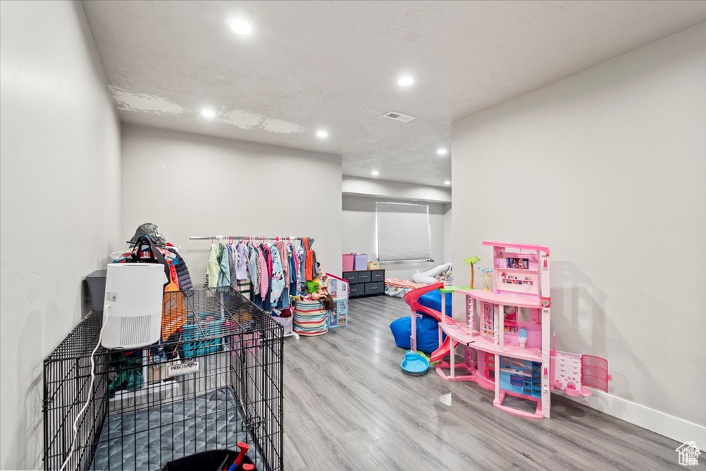 Playroom with wood finished floors, recessed lighting, and baseboards