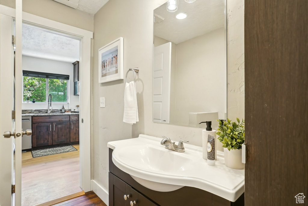 Bathroom with wood finished floors, vanity, and baseboards