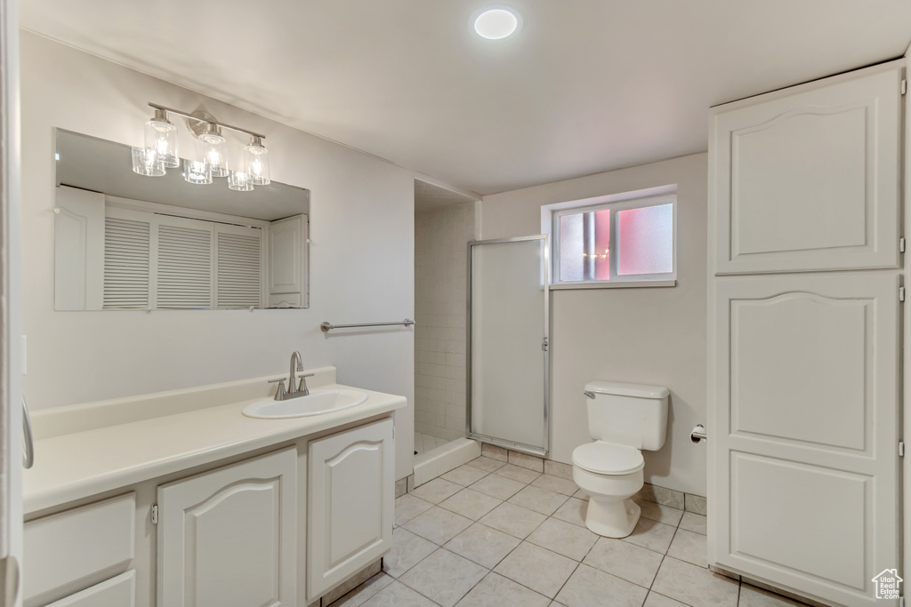 Bathroom with tile patterned floors, toilet, a shower stall, and vanity
