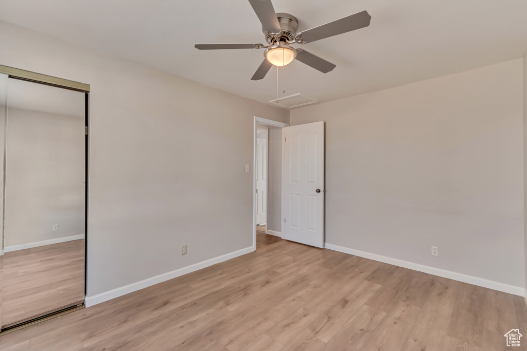 Unfurnished bedroom featuring baseboards, light wood-style flooring, a closet, and ceiling fan