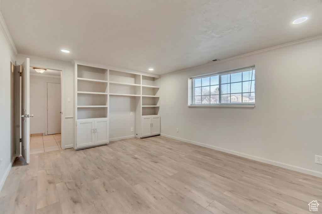 Spare room with crown molding, light wood-style floors, baseboards, and recessed lighting