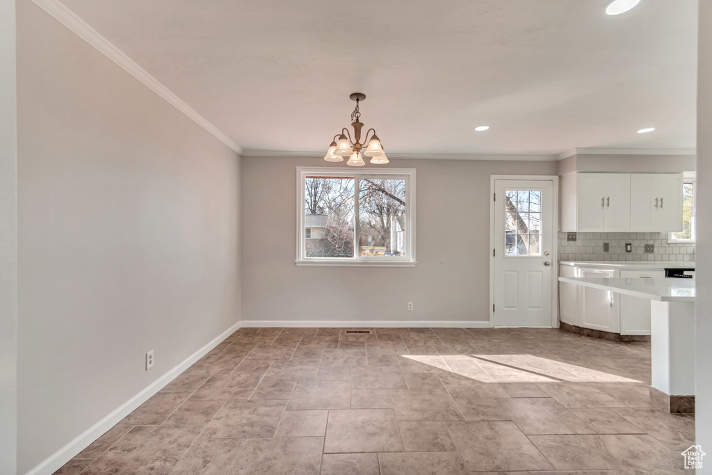 Unfurnished dining area featuring crown molding, a chandelier, baseboards, and recessed lighting