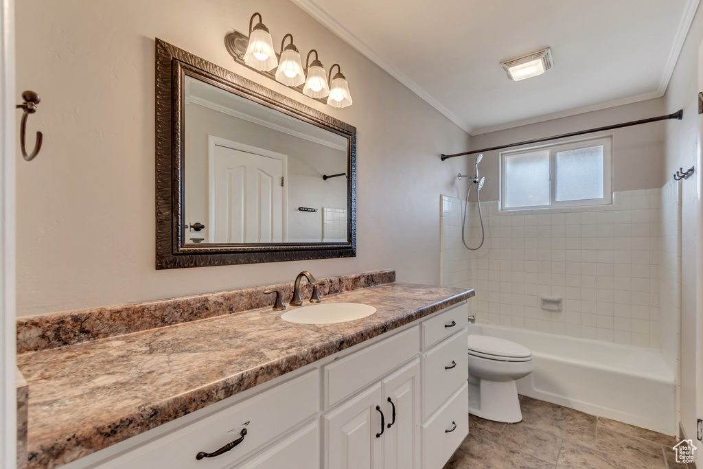 Bathroom featuring vanity, crown molding, toilet, and shower / tub combination