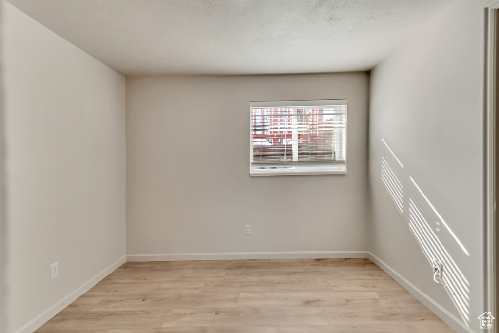 Unfurnished room with light wood-style flooring and baseboards