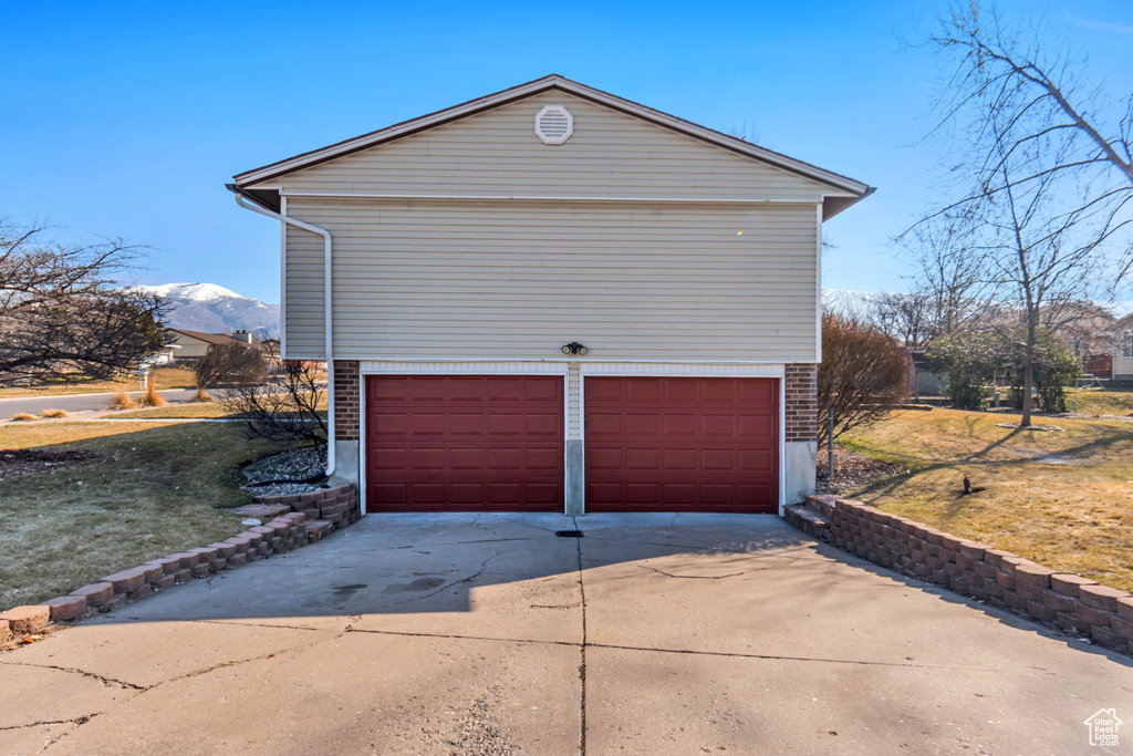 Garage featuring driveway and a mountain view