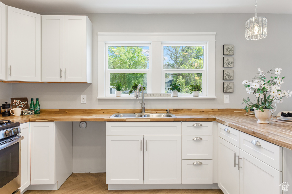 Kitchen with wood counters, a sink, and healthy amount of natural light