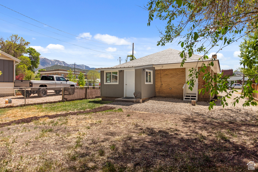 Rear view of house with a mountain view and fence
