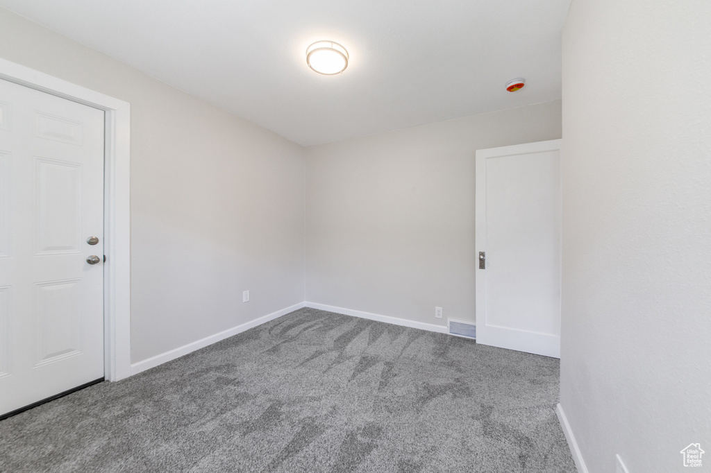 Spare room featuring carpet and baseboards