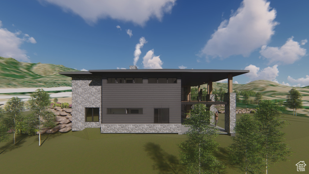 Back of property with stone siding, a balcony, and a mountain view