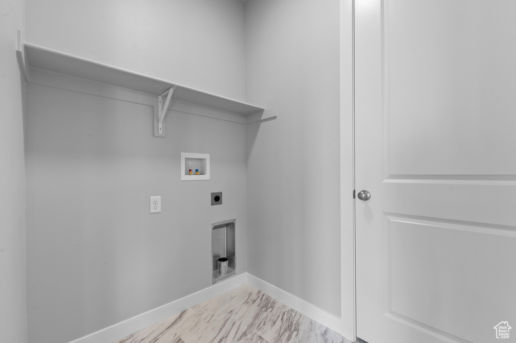 Laundry room with hookup for an electric dryer, washer hookup, marble finish flooring, and baseboards