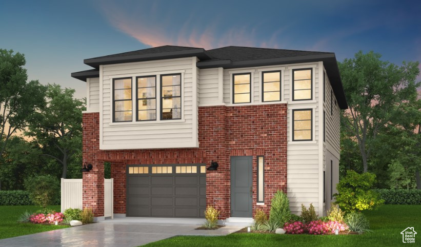 View of front of home featuring an attached garage, brick siding, driveway, and a front yard
