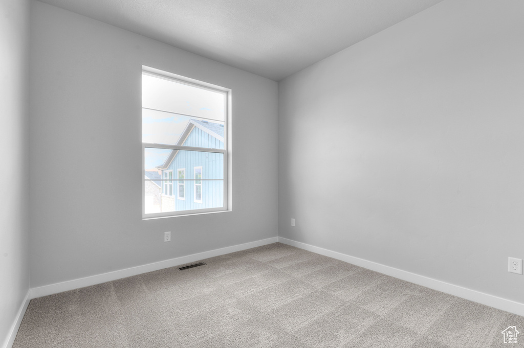Carpeted empty room featuring baseboards
