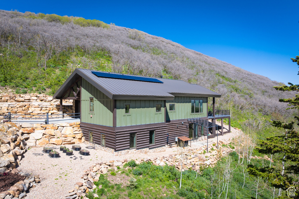 Back of property featuring board and batten siding, solar panels, and a mountain view