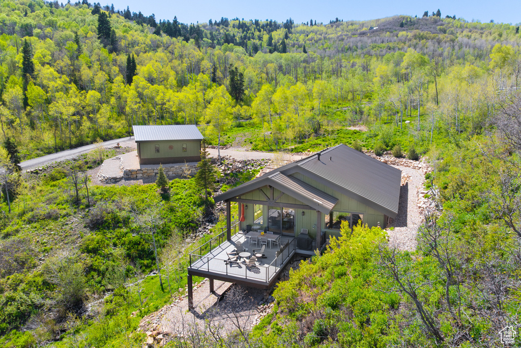 Aerial view of property and surrounding area with a forest