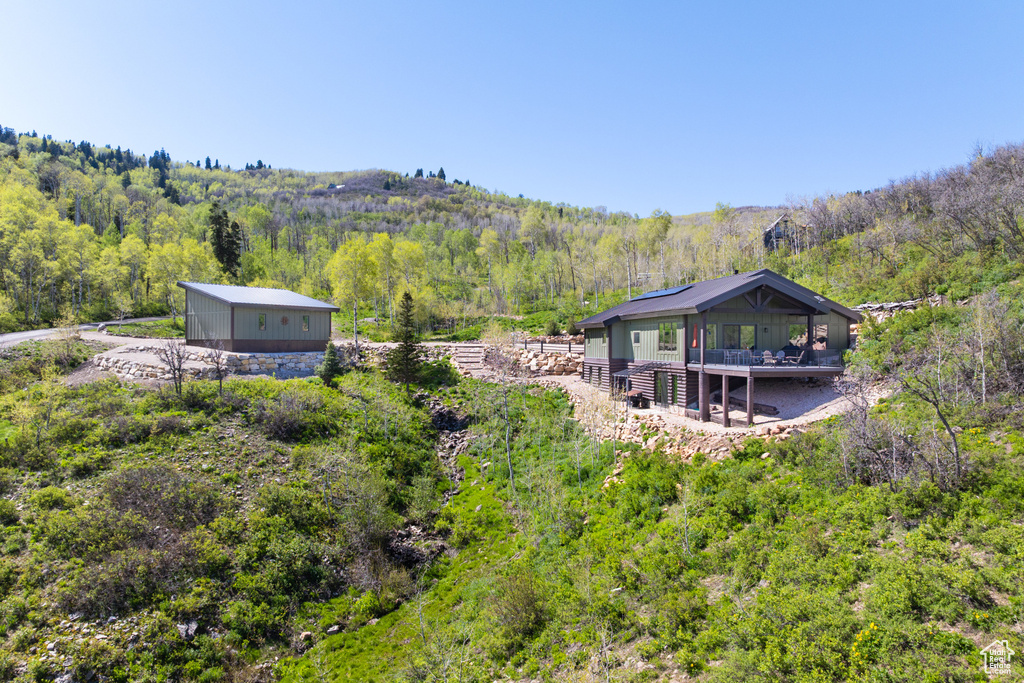 Back of property with a wooded view