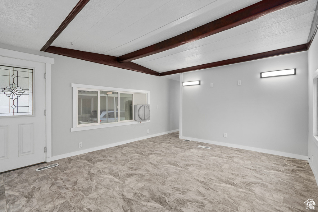 Foyer with beamed ceiling and baseboards
