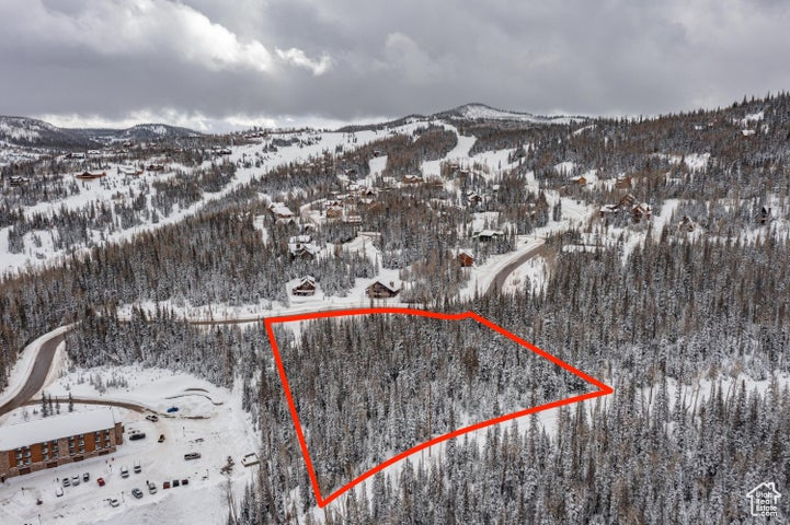 Snowy aerial view with a mountain view and property boundaries highlighted