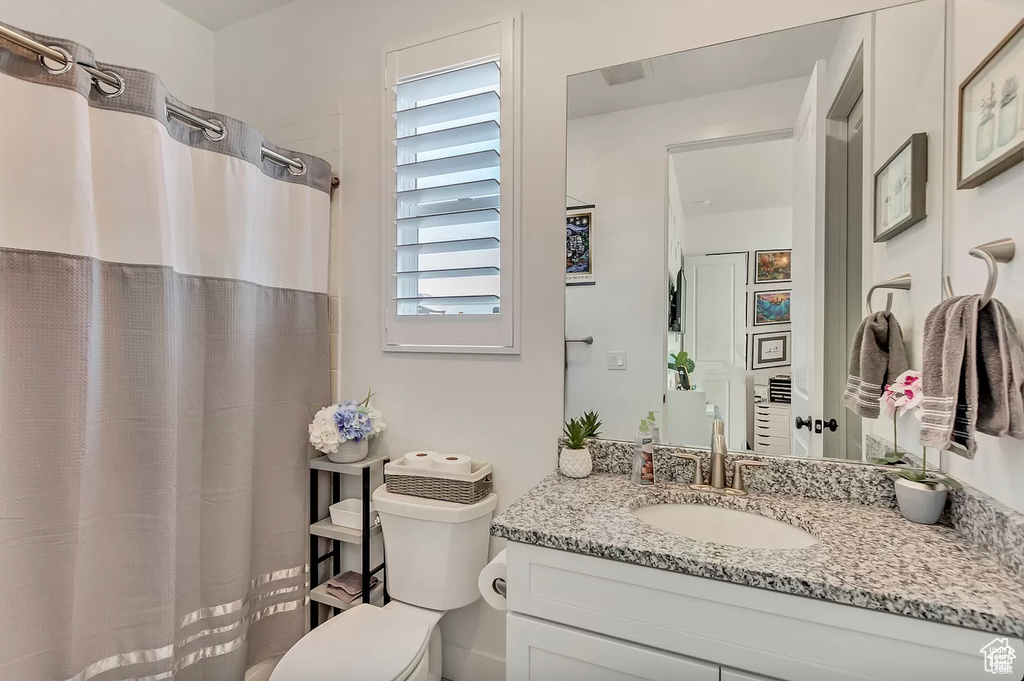 Full bathroom featuring vanity, toilet, and curtained shower